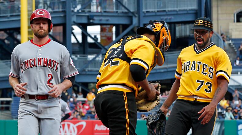 Pittsburgh Pirates catcher Elias Diaz, center, takes a toss from pitcher Felipe Rivero (73) to get the force at home on Cincinnati Reds’ Zack Cozart (2) to end a baseball game in Pittsburgh, Sunday, Sept. 3, 2017. The Pirates won 3-1. (AP Photo/Gene J. Puskar)