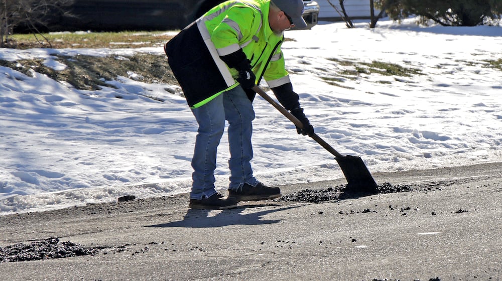 Tait Schnitzler, an employee of the City of Springfield, patches a pot hole along Superior Avenue Tuesday, Jan. 28, 2025. STAFF
