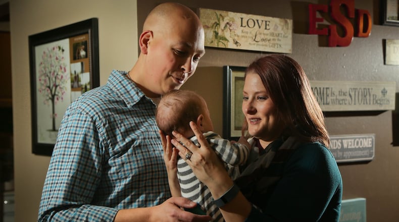 Elizabeth and Daniel Schreier, of Fairborn, hold their foster son in 2015. JIM WITMER/STAFF