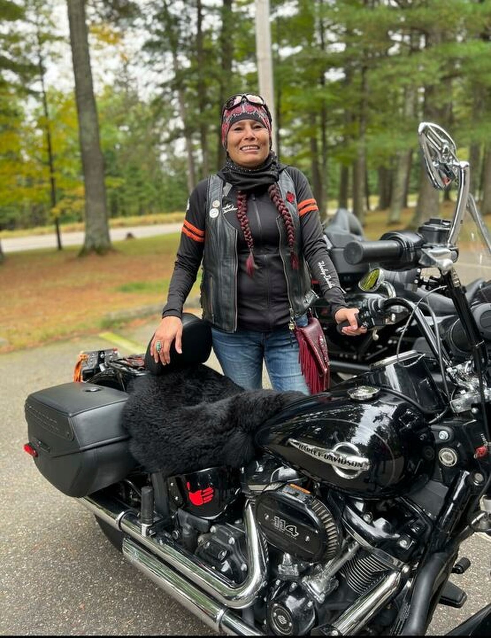 In this photo provided by Shawn Milligan, Lisa Milligan of the Forest County Potawatomi tribe poses with her motorcycle, adorned with a red hand, at a Missing & Murdered Indigenous Women event at the Lac du Flambeau Band of Lake Superior Chippewa reservation in Wisconsin, May 5, 2022. (Shawn Milligan via AP)