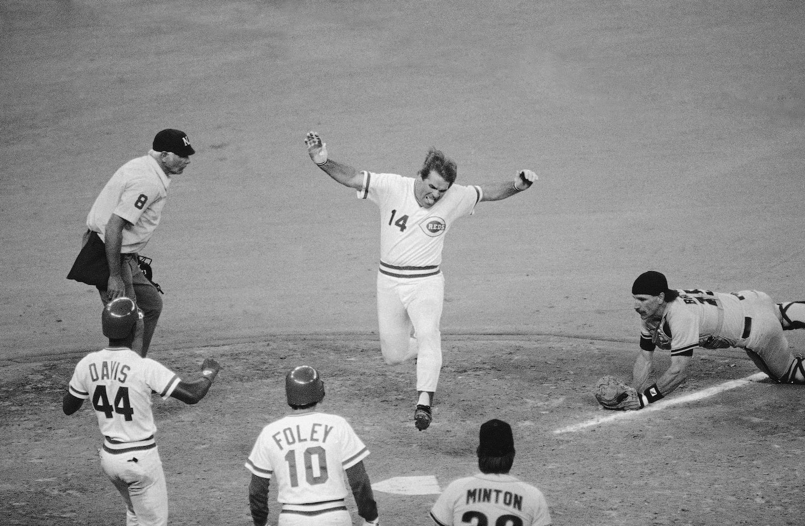 FILE - Cincinnati Reds player-manager Pete Rose leaps onto home plate as he scores the winning run in the 10th inning of a baseball game against the San Francisco Giants at Riverfront Stadium in Cincinnati, April 19, 1985. (AP Photo/Al Behrman, File)