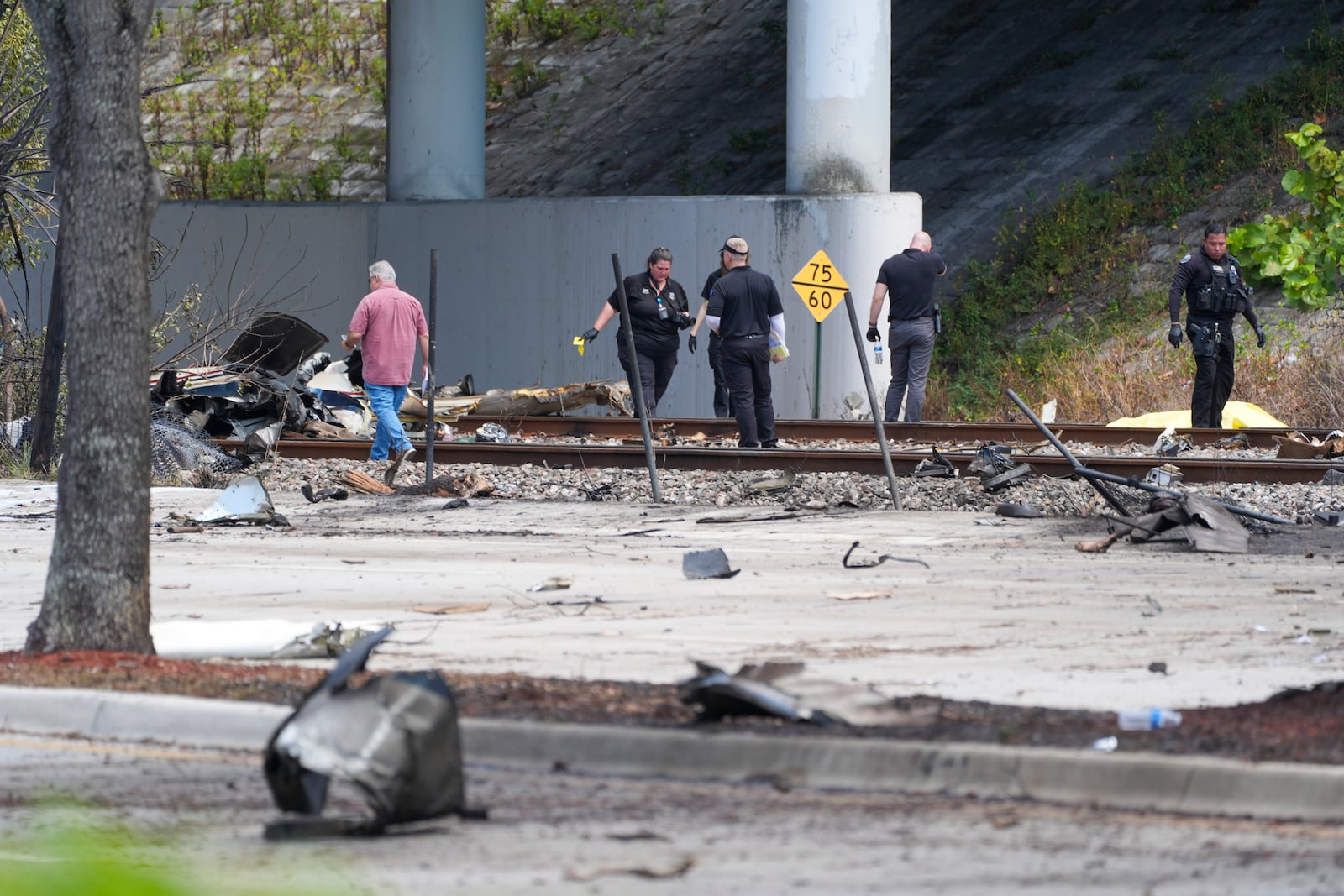 Emergency crew inspect the site of a small plane crash Friday, April 11, 2025 in Boca Raton, Fla. (AP Photo/Marta Lavandier)