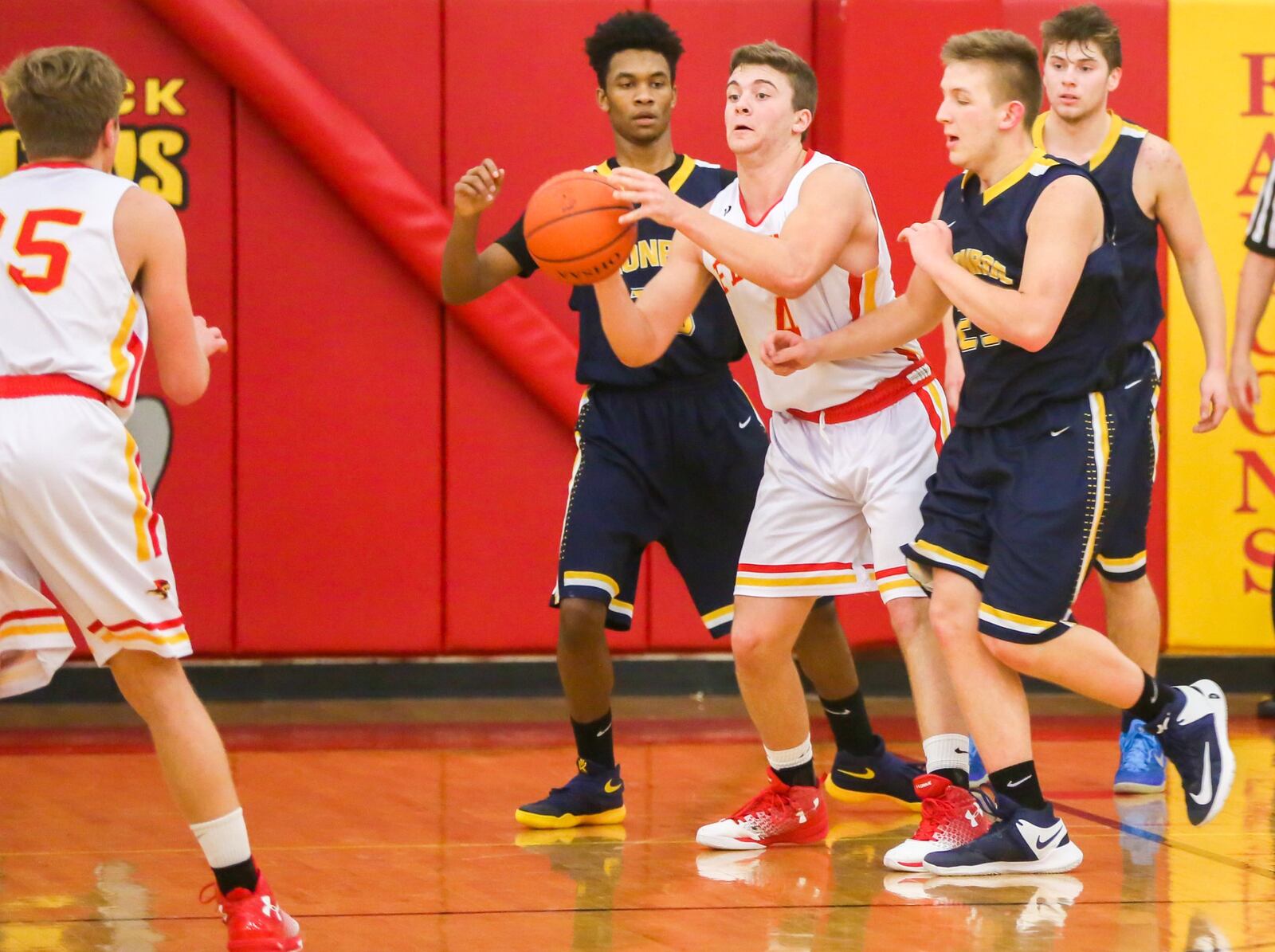 Fenwick forward Sammy DeBiasi (4) kicks a pass out to teammate Luke Bradshaw (35) from between Monroe’s Tristan Backas (left) and Matt DeHart (25) on Tuesday night at Fenwick. GREG LYNCH/STAFF