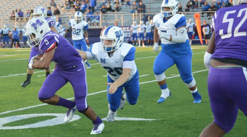 Hamilton’s Elijah Spradling (20) gets a hand on Middletown running back Diondre Cooper (5) during a game at Barnitz Stadium in Middletown on Sept. 29, 2017. The visiting Big Blue won 47-26. CONTRIBUTED PHOTO BY MARITZA MCKINNEY