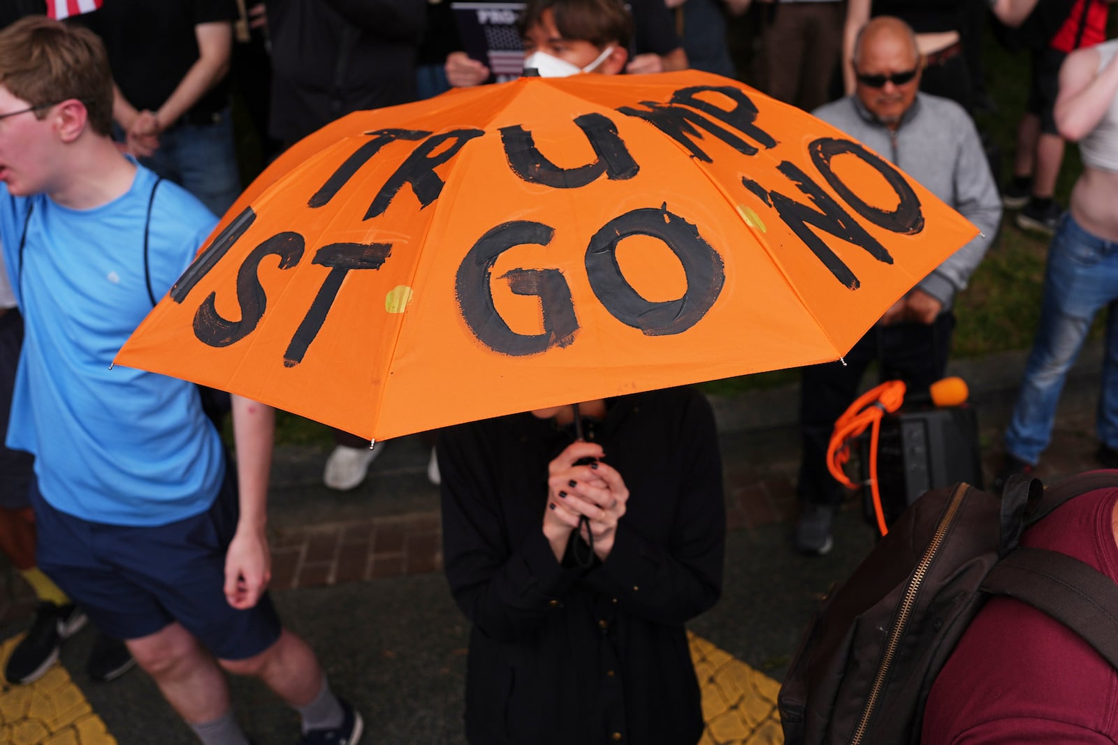 A demonstrators carries an umbrella with protest language on it during before a march taking place on the day of a military parade commemorating the Army's 250th anniversary, coinciding with President Donald Trump's 79th birthday, Saturday, June 14, 2025, in Washington. (AP Photo/Evan Vucci)