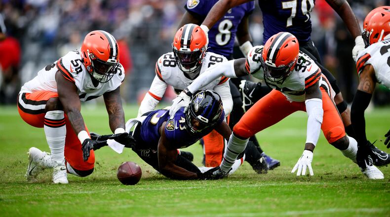 Cleveland Browns defensive end Isaiah Thomas (58) recovers Baltimore Ravens running back Justice Hill's (43) fumble infant of Cleveland Browns linebacker Jeremiah Owusu-Koramoah (28) and safety Ronnie Harrison Jr. (33) in the second half of an NFL football game, Sunday, Oct. 23, 2022, in Baltimore. (AP Photo/Nick Wass)