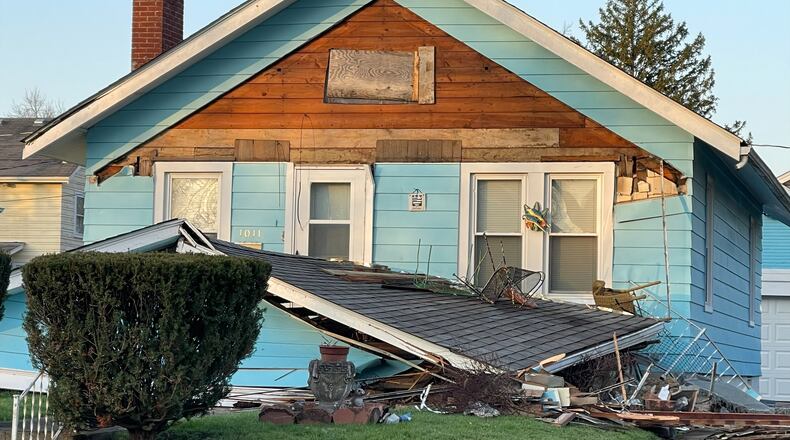 A vehicle crashed into a Hamilton house at Park and Haven Monday, ripping off the porch. MANDY GAMBRELL/STAFF