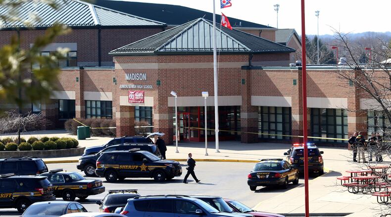 FILE— In this file photo from Feb. 29, 2016, Butler County Sheriff Deputies stand on the scene at Madison Local Schools, in Madison Township in Butler County, Ohio, after a school shooting. After the 2016 shooting, a group of parents sued the district in September 2018 to prevent teachers from being armed without extensive training. The Ohio Supreme Court ruled Wednesday, June 23, 2021 that armed school employees must undergo an approved basic peace-officer-training program or have 20 years experience as a police officer. (Cara Owsley/The Cincinnati Enquirer via AP)