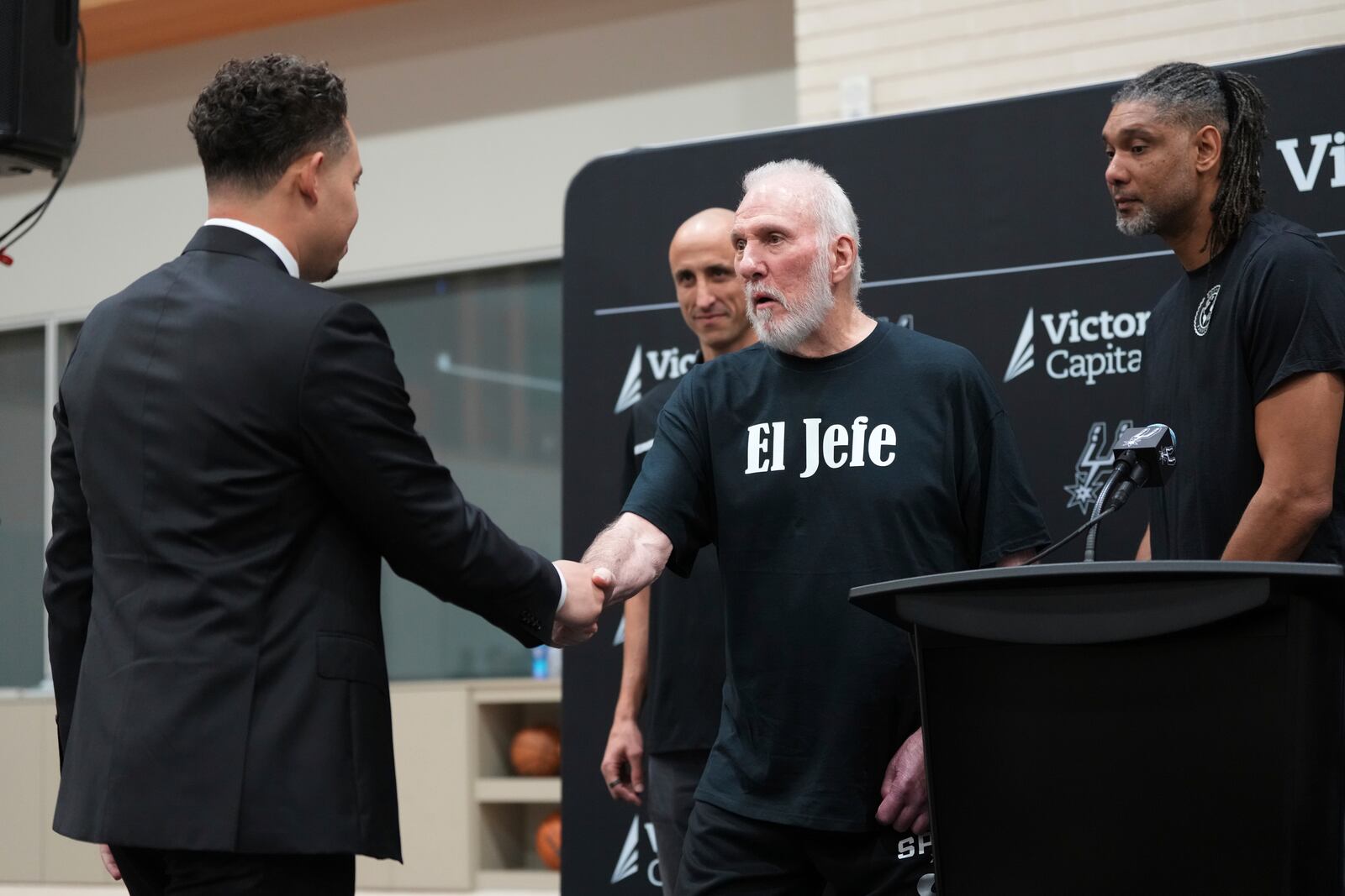 With the help of former players Manu Ginobili, back left, and Tim Duncan, right, former San Antonio Spurs head coach Gregg Popovich, center, introduces Mitch Johnson, left, as the new head coach of the San Antonio Spurs NBA basketball team, in San Antonio, Monday, May 5, 2025. (AP Photo/Eric Gay)