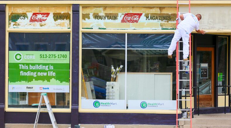 In this 2016 file photo, Danny Taylor of Taylor’s Painting works on the windows at Hughes Drugs building at 302 Main St. in Hamilton. The city received high marks in a recent study for its efforts to shift from a manufacturing-based economy to a post-industrial age. GREG LYNCH/STAFF