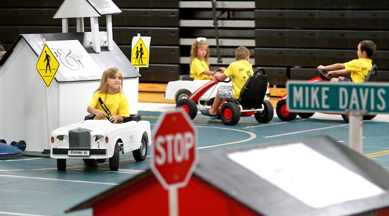 In this 2014 photo, Kayla Greer (left) rides the streets of Safety Town with fellow students at Amanda Elementary School in Middletown. NICK DAGGY / STAFF