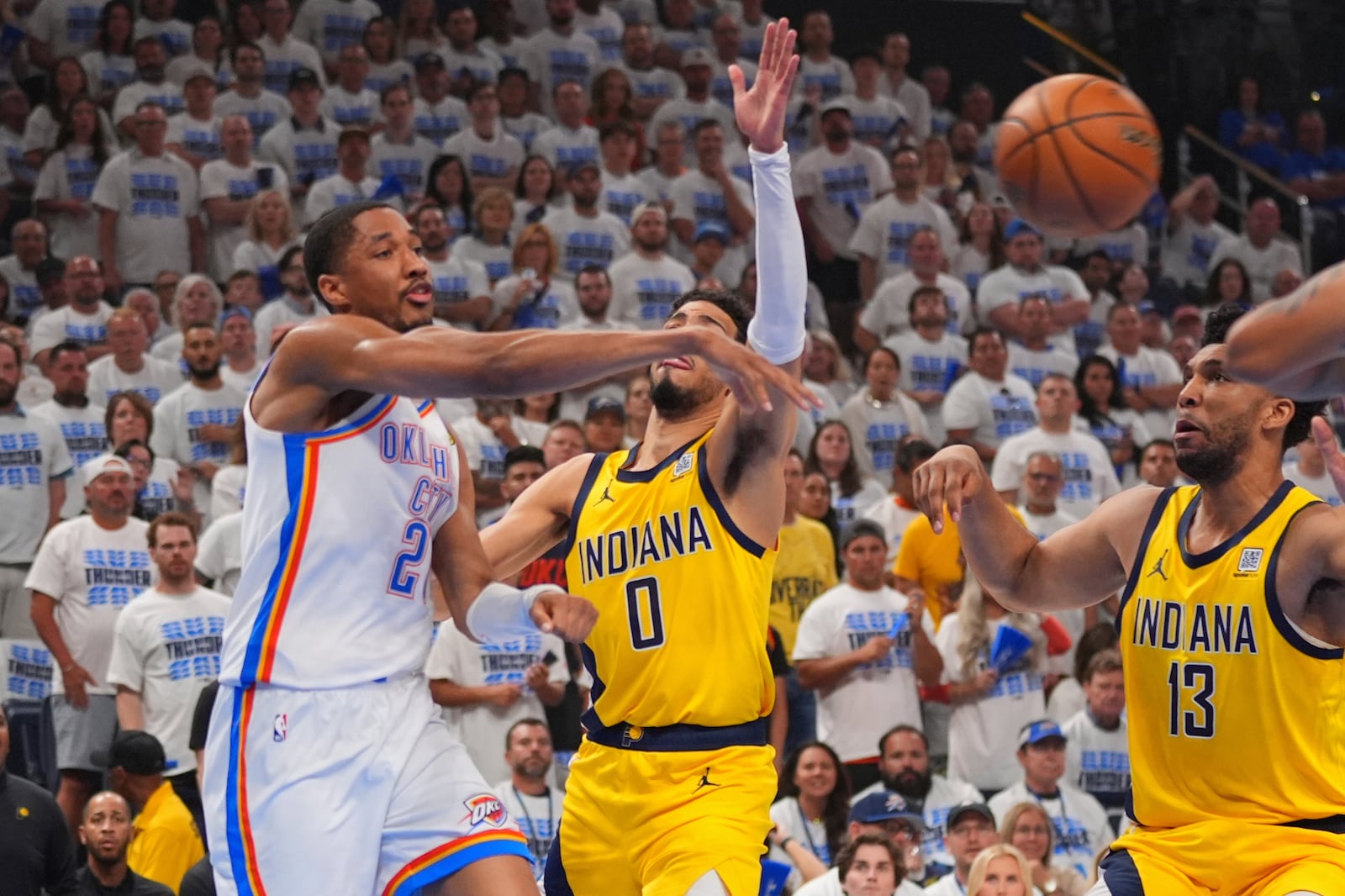Oklahoma City Thunder guard Shai Gilgeous-Alexander (2) dishes off as Indiana Pacers guard Tyrese Haliburton (0) defends during the first half of Game 5 of the NBA Finals basketball series, Monday, June 16, 2025, in Oklahoma City. (AP Photo/Kyle Phillips)