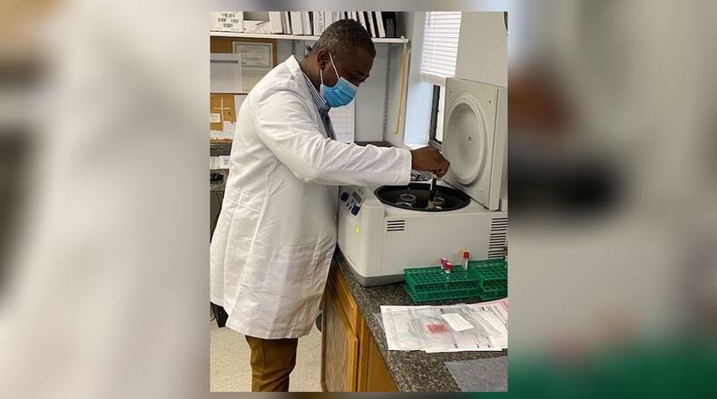 Kofi Amoah places a blood sample in a centrifuge to check for antibodies. Amoah is also doing work to start a mobile vaccine clinic. CONTRIBUTED