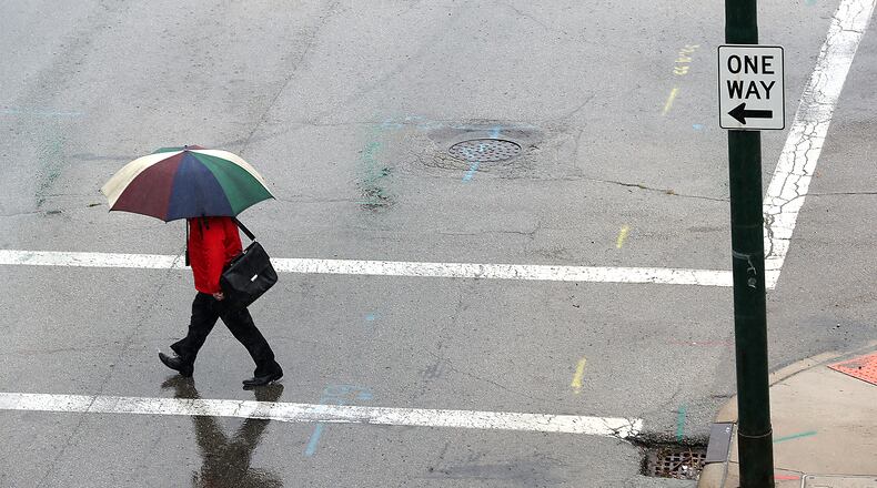 A man with an umbrella crosses Columbia Street in the rain Wednesday. The first day of Fall was soggy one Wednesday, with rain showers throughout the day. BILL LACKEY/STAFF