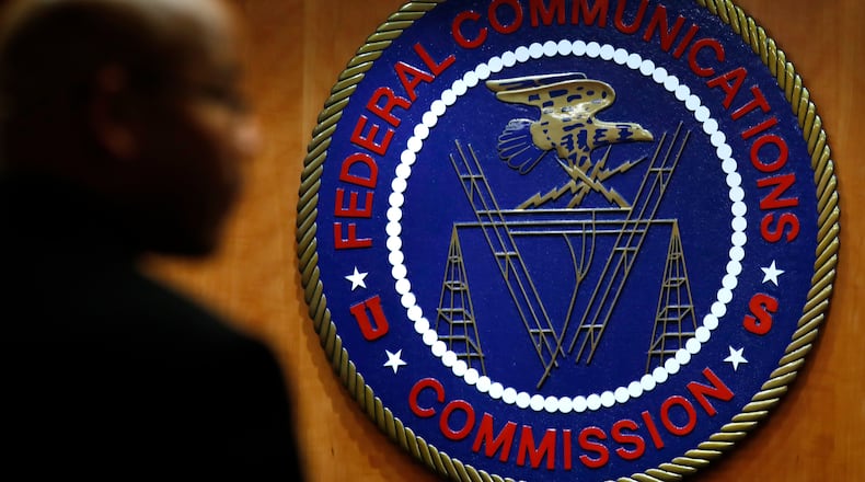 FILE- This Dec. 14, 2017, file photo, shows the seal of the Federal Communications Commission (FCC) before a meeting in Washington. Congressional leaders and a media accountability organization are urging the Federal Communications Commission to investigate its "history of racism" and examine how policy decisions have disparately harmed Black people and other communities of color, according to a letter sent Tuesday, June 29, 2021, to the acting FCC chair. (AP Photo/Jacquelyn Martin, File)