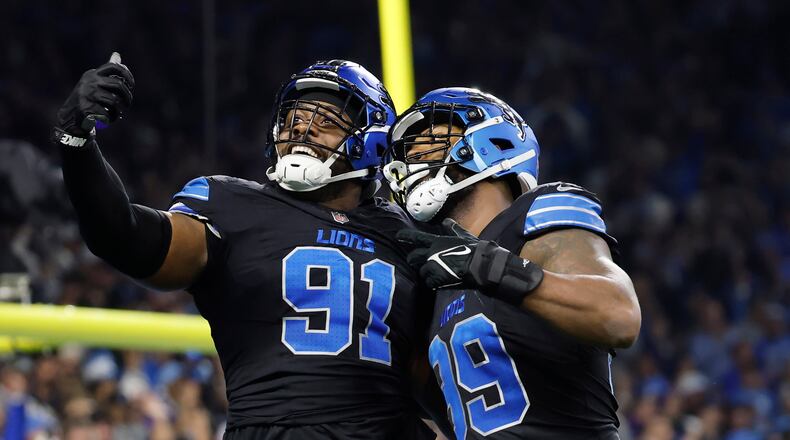 Detroit Lions defensive end Levi Onwuzurike (91) and defensive end Za'Darius Smith (99) celebrate a play against the Minnesota Vikings during the first half of an NFL football game Sunday, Jan. 5, 2025, in Detroit. (AP Photo/Rey Del Rio)