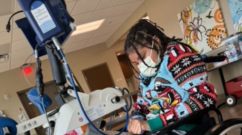 Anaiah Prier, 14, an eighth-grader, is on a motorized physical therapy bike at Bethany Children's Health Center. SUBMITTED PHOTO