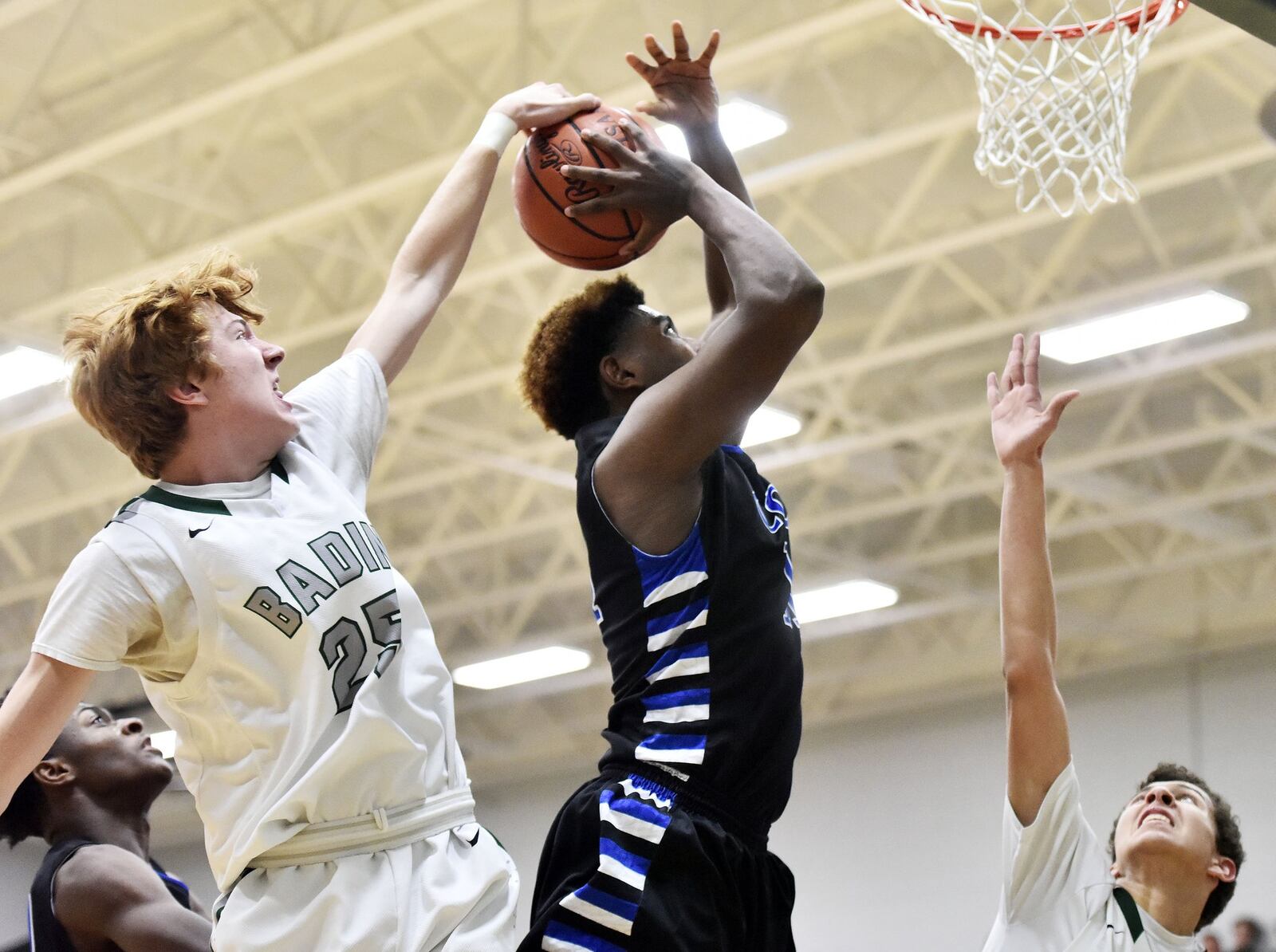 Badin’s Zachary Switzer blocks a shot by Cincinnati Christian’s Wayne Lavender during their game Friday night at Mulcahey Gym in Hamilton. NICK GRAHAM/STAFF