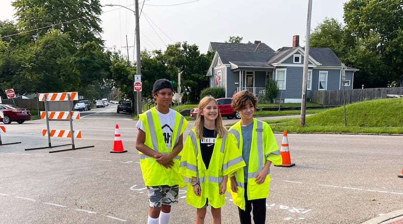 Three Hamilton Highland Elementary 6th graders just made walking to and from school safer for hundreds of classmates with their grant-seeking project that saw the recent creation of a new cross walk. The now 7th graders wrote and pitched for local grant funds to help the city create the new cross walk. Pictured here (L-R) at the crosswalk dedication, which was attended by Hamilton Mayor Pat Moeller, are Xavier Hoxie, Malin Matheny and Kamyn Frazier. (Provided Photo\Journal-News)