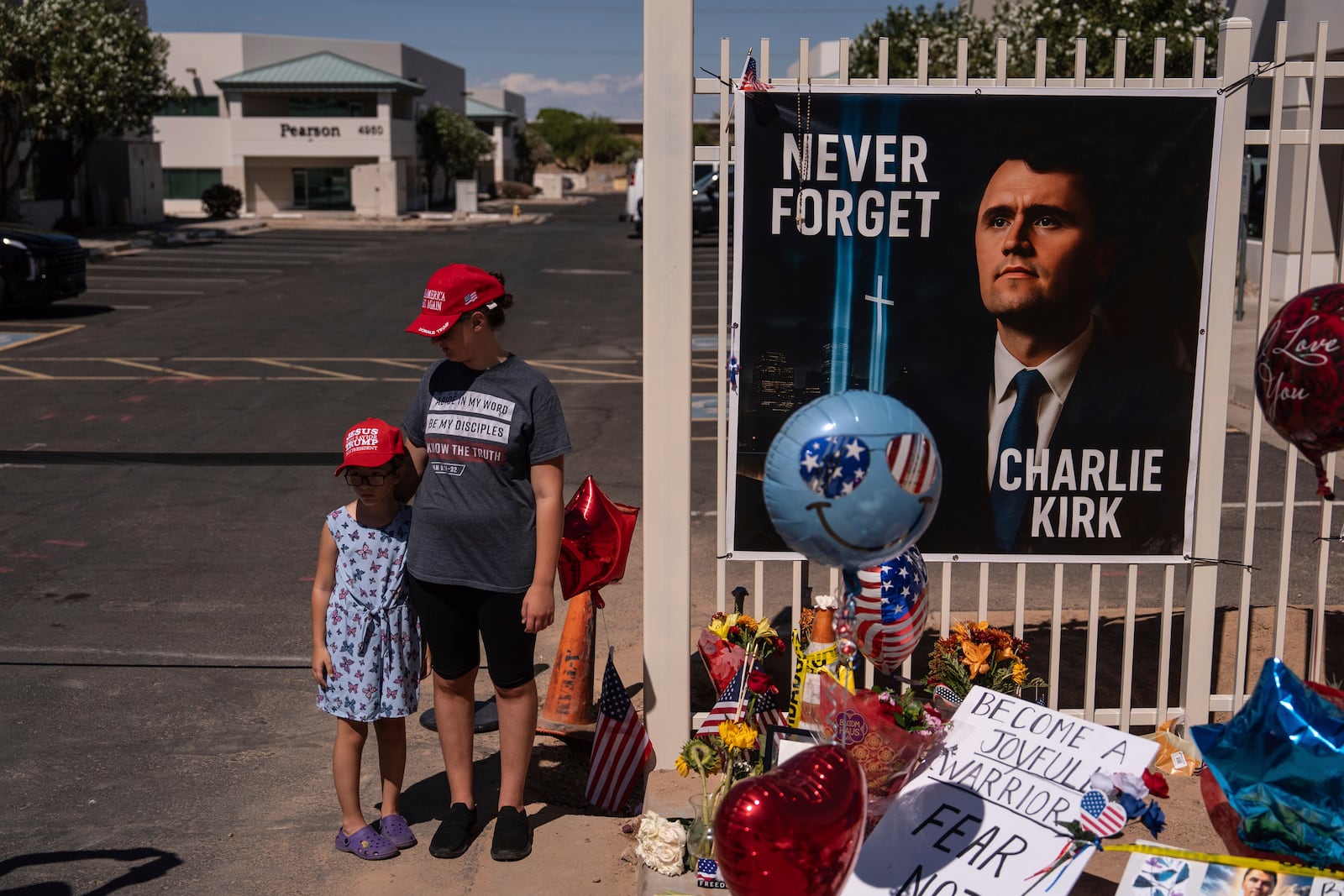 Nicole and Amalia, who asked to be identified by their first names only, stand for a photo at a makeshift memorial for Charlie Kirk outside Turning Point USA headquarters in Phoenix Saturday, Sept. 20, 2025. (AP Photo/Jae C. Hong)