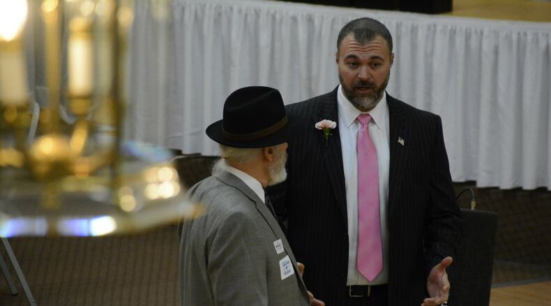 Butler County GOP Executive Committee Chairman Todd Hall talks with a county party central committee member ahead of the party’s endorsement meeting Tuesday night, Jan. 30, 2018, at Tori’s Station in Fairfield. He, along with several other members, wore some type of pink clothing and/or a pink flower to support the women in light of recent sexist and demeaning allegations made by male state lawmakers. MICHAEL D. PITMAN/STAFF