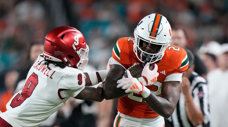 Miami (Ohio) defensive back Jeremiah Caldwell (9) pushes Miami running back Mark Fletcher Jr. out of bounds during the first half of an NCAA college football game, Friday, Sept. 1, 2023, in Miami Gardens, Fla. (AP Photo/Wilfredo Lee)