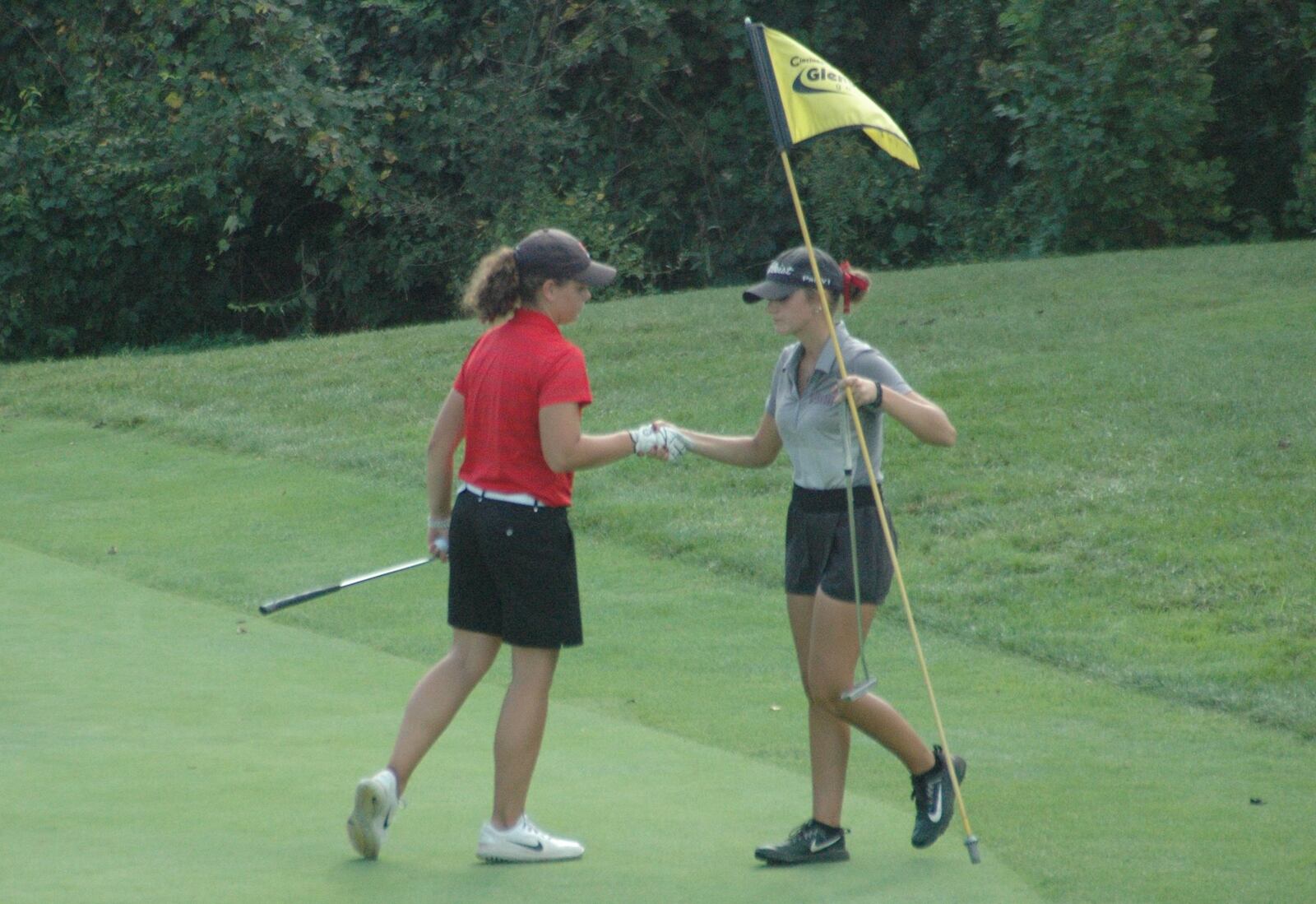Lebanon’s Maddie Owens (right) and Colerain’s Alex Schutte shake hands after Schutte won a one-hole playoff Tuesday at the Division I district girls golf tournament at Glenview Golf Course. Schutte was the last individual to qualify for a trip to the state tournament. RICK CASSANO/STAFF
