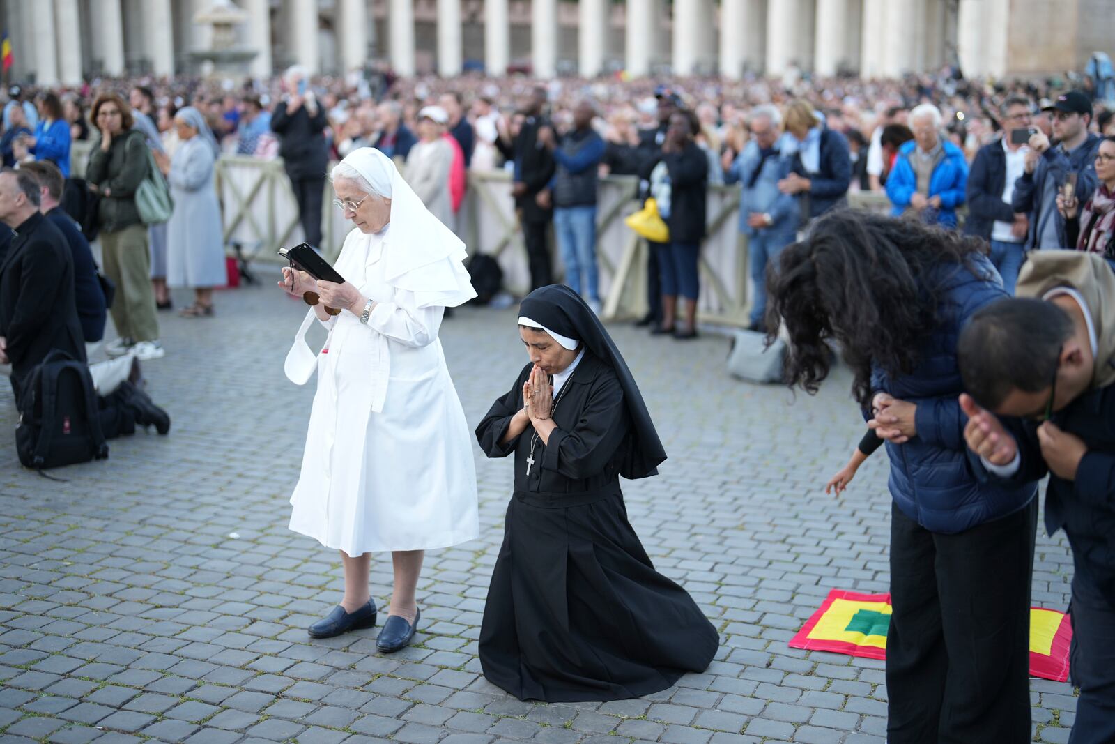 A nun from Peru, center, prays during the speech of the newly elected Pope Leo XIV at the Vatican, Thursday, May 8, 2025. (AP Photo/Francisco Seco)