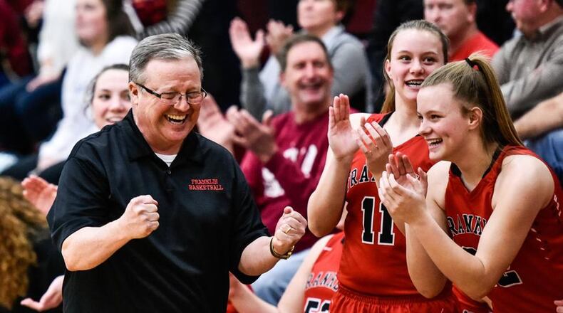 Franklin coach John Rossi starts to enjoy his team’s Division II sectional championship with Kristin Earles (11) and Madison Earles (22) late in Monday night’s game against Monroe at Lebanon. NICK GRAHAM/STAFF