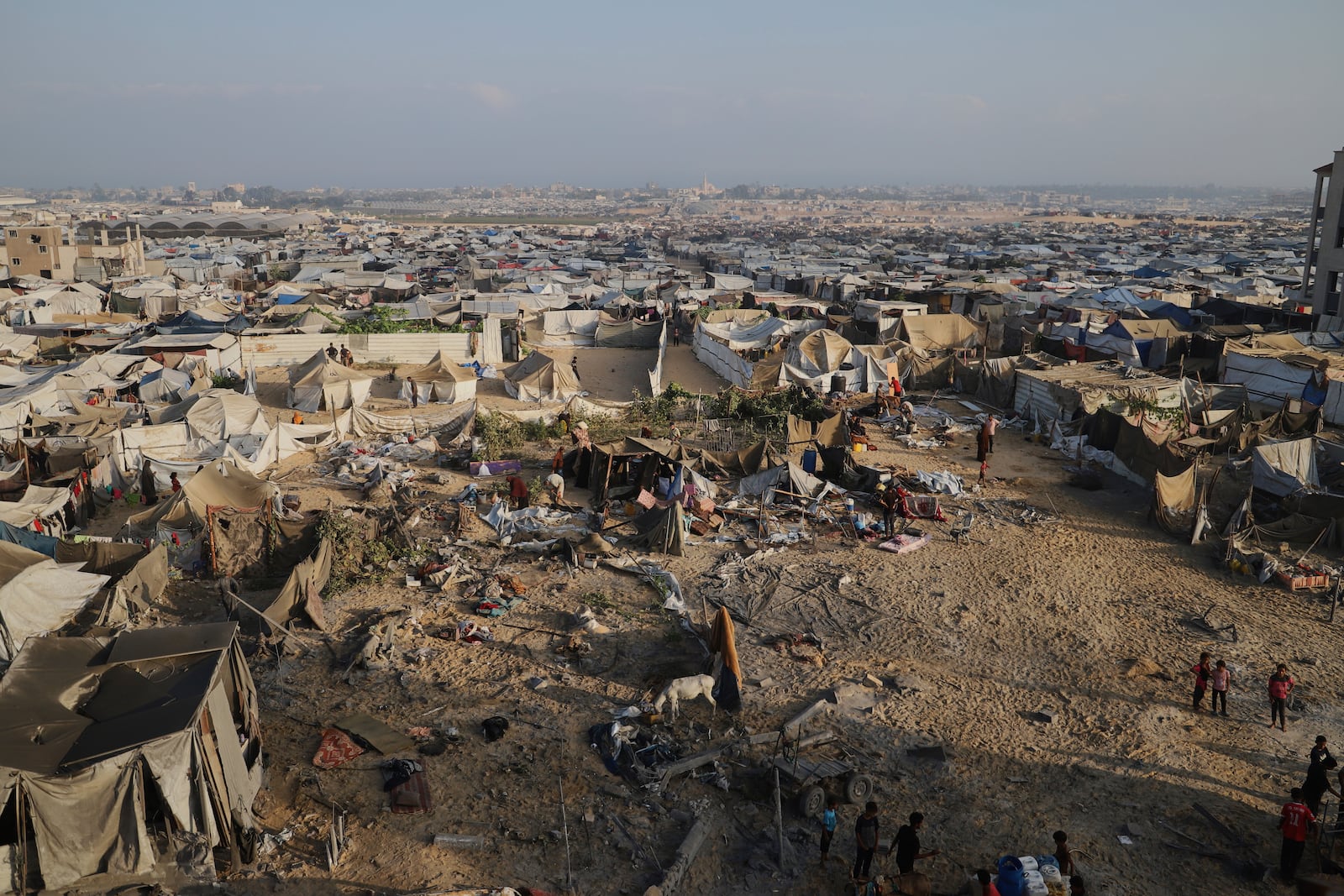 Palestinians inspect the site struck by an Israeli bombardment in Muwasi, Khan Younis, Gaza Strip, Monday, July 28, 2025. (AP Photo/Mariam Dagga)