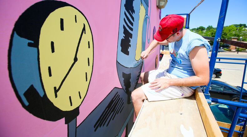 Artist Stephen Smith works on a mural last summer in Hamilton. Artists have until midnight Feb. 12 to submit design ideas for possible inclusion in Hamilton’s StreetSpark program this summer. STAFF FILE/ 2016