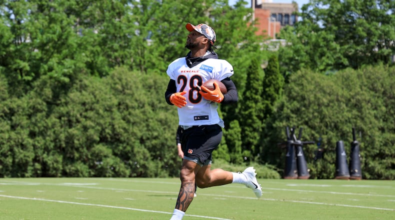 Cincinnati Bengals' Joe Mixon carries the ball as he participates in a drill during an NFL football practice in Cincinnati, Tuesday, May 24, 2022. (AP Photo/Aaron Doster)