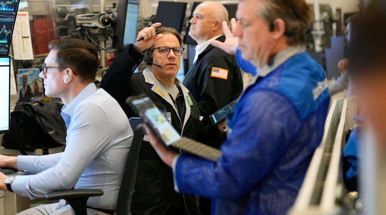 Anthony Spina, center, works on the floor at the New York Stock Exchange in New York, Wednesday, Dec. 10, 2025. (AP Photo/Seth Wenig)
