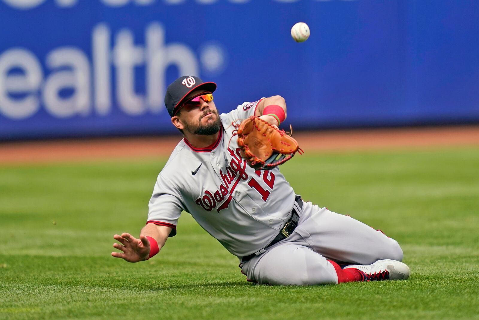 Washington Nationals left fielder Kyle Schwarber makes a sliding catch during the fourth inning of a baseball game against the New York Mets at Citi Field, Sunday, April 25, 2021, in New York. (AP Photo/Seth Wenig)