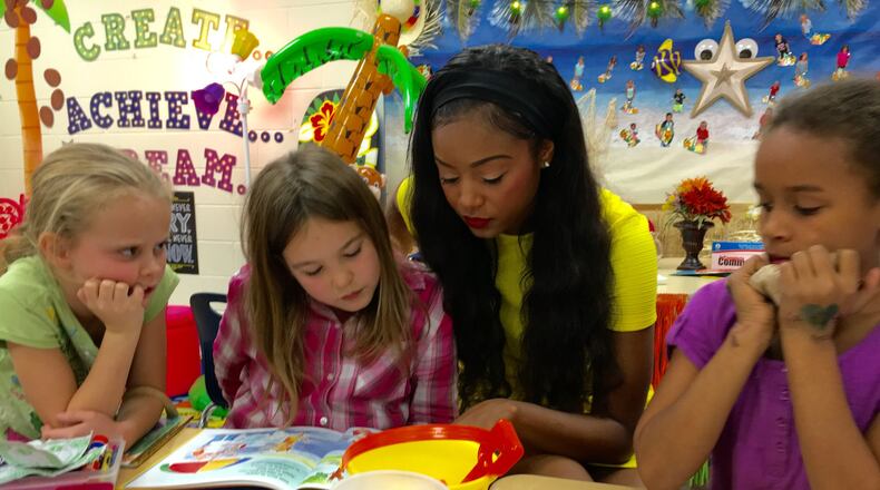 Au’Lauren Million, a Middletown High School senior and the recent winner of the school’s homecoming queen crown, helps youngsters at Wildwood Elementary learn to read. MICHAEL D. CLARK/STAFF