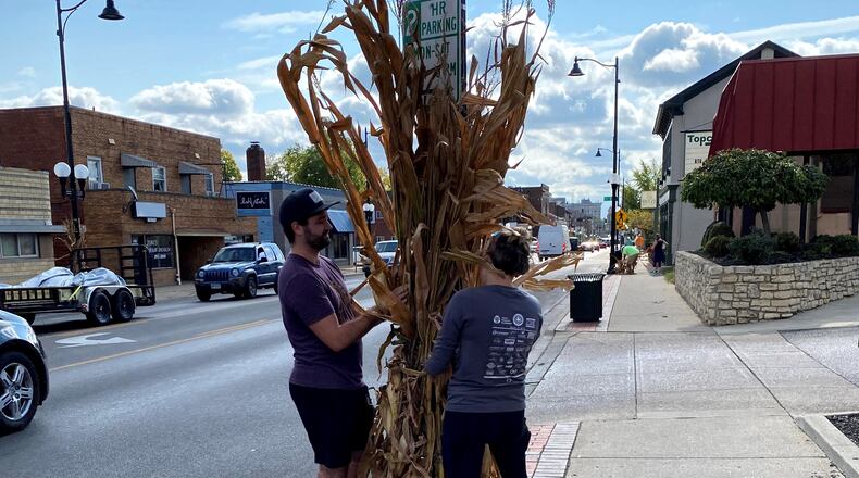 Volunteers in recent days decorated poles along Main Street with corn stalks in preparation for Operation Pumpkin. PROVIDED