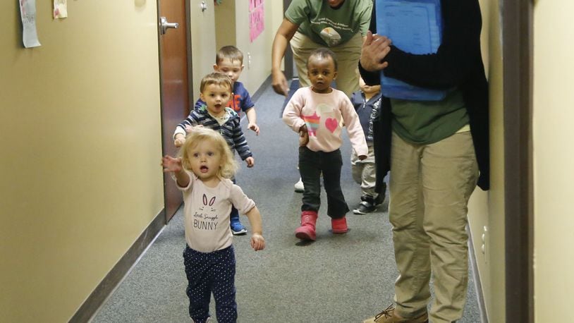 Good Shepherd Academy center toddlers sing a walking song as they walk the hallway at the Jubilee Community Church in Springboro. TY GREENLEES / STAFF