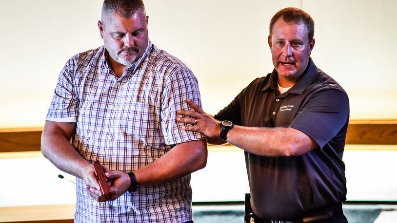 Ken Henderson, Pastor of Quest Church, left, helps Middletown Division of Police Major David Birk, right, with a demonstration during an active shooter/awareness training class put on by Middletown Police Monday, August 12 in Middletown city council chambers. NICK GRAHAM/STAFF