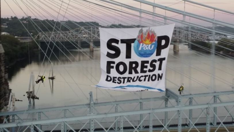 The Rainforest Action Network at the John A. Roebling Suspension Bridge in Cincinnati on Wednesday said it is protesting against actions taken by Procter & Gamble. They dropped a banner off the side of the bridge that reads “stop forest destruction.” WCPO/CONTRIBUTED