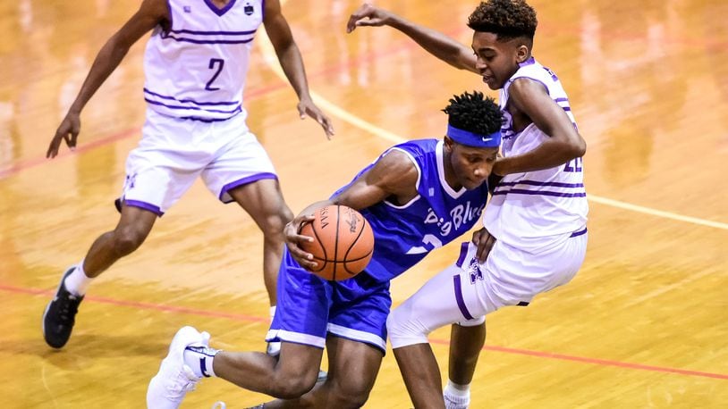 Hamilton’s D’Marco Howard dribbles the ball defended by Middletown’s Johrdon Mumford as Middletown Middies hosted Hamilton Big Blue in the final game at Wade E. Miller Gymnasium at Middletown Middle School on Friday, Dec. 8 in Middletown. NICK GRAHAM/STAFF