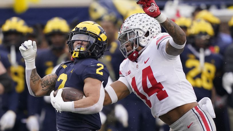 Michigan running back Blake Corum (2) is chased by Ohio State safety Ronnie Hickman (14) during the second half of an NCAA college football game, Saturday, Nov. 27, 2021, in Ann Arbor, Mich. (AP Photo/Carlos Osorio)