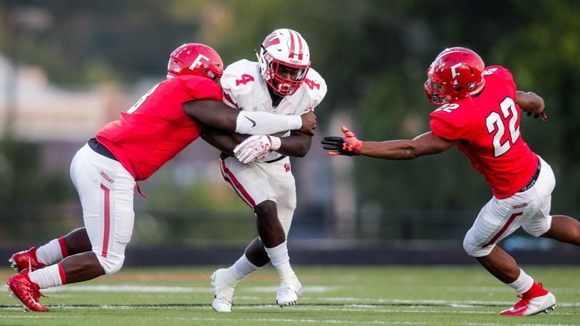 Lakota West’s David Afari carries the ball and is surrounded by Fairfield’s Greg Fitzpatrick (left) and Dealo McIntosh during Sept. 14 game at Fairfield Stadium. Fairfield won 37-3. NICK GRAHAM/STAFF