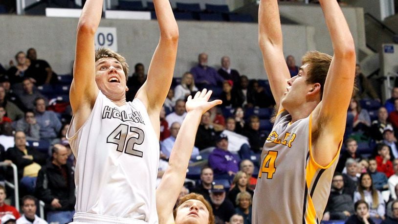 Lakota East’s Dylan Lowry (23) takes a shot while being defended by Moeller’s Jack Anton (14) during a Division I sectional game Feb. 28, 2014, at Xavier University’s Cintas Center. Moeller won 55-42. JOURNAL-NEWS FILE PHOTO