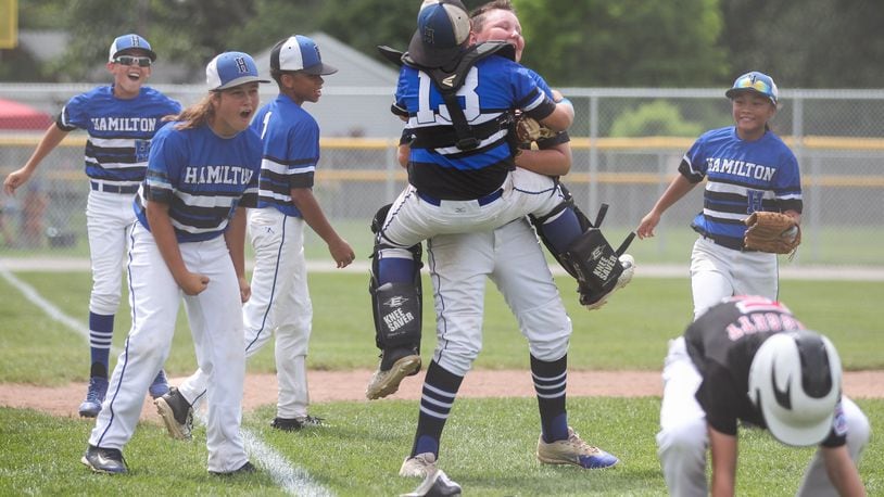 Hamilton West Side’s Blake Detherage (13) jumps into the arms of teammate Casey Parsons after Parsons tagged Canfield’s Connor Daggett (5) for the final out Thursday in the winners’ bracket final of the Ohio Little League 12-year-old baseball tournament at Ford Park in Maumee. CONTRIBUTED PHOTO BY SCOTT GRAU