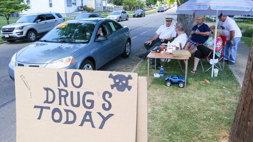 Parkamo Avenue resident Denny Matheny placed a sign Monday, July 31, outside his home in an effort to curb drug use in the neighborhood. Matheny was joined throughout the day by Hamilton Police Chief Craig Bucheit as well as various neighbors, family members and even strangers in support of his efforts. GREG LYNCH/STAFF