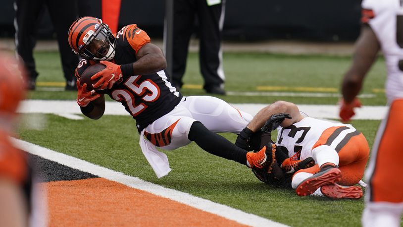 Cincinnati Bengals' Giovani Bernard (25) goes in for a touchdown while being tackled by Cleveland Browns' Andrew Sendejo (23) during the second half of an NFL football game, Sunday, Oct. 25, 2020, in Cincinnati. (AP Photo/Michael Conroy)