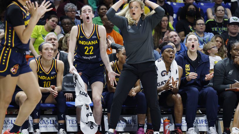 Indiana Fever guard Caitlin Clark (22) and head coach Christine Sides, center right, react after a play during the second half of an WNBA basketball game against the Dallas Wings in Arlington, Texas, Friday, May 3, 2024. (AP Photo/Michael Ainsworth)