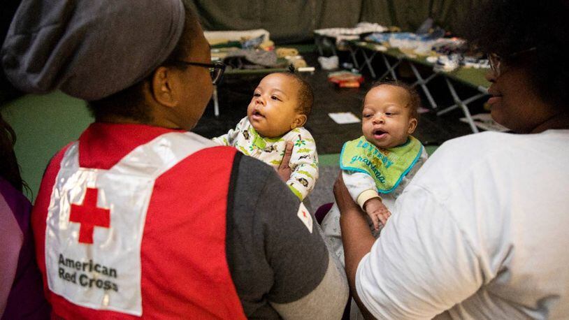 Red Cross volunteer Denisha (left) holds Gaberl, 5 months old, as mom Quanisha (right) holds Rapheal, also 5 months old, at Red Cross shelter for people displaced by the tornado. Red Cross photo by Scott Dalton