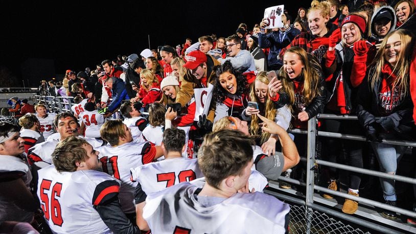 Madison’s players celebrate with their student section last Friday night after the Mohawks defeated West Jefferson 42-7 in the Division V, Region 20 championship game at Frank Zink Field in Beavercreek. NICK GRAHAM/STAFF