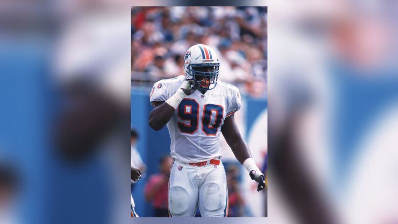 12 Nov 1995: Defensive end Marco Coleman of the Miami Dolphins adjusts his chin strap during the Dolphins 34-17 loss to the New England Patriots at Joe Robbie Stadium in Miami, Florida.